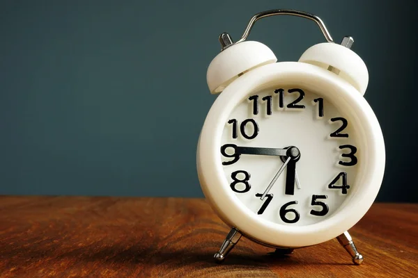 Procrastinación y concepto de gestión del tiempo. Reloj despertador en una mesa . — Foto de Stock