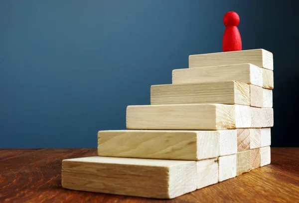 Personal development and growth, success in career concepts. Stairs and red figurine as symbol of leader.
