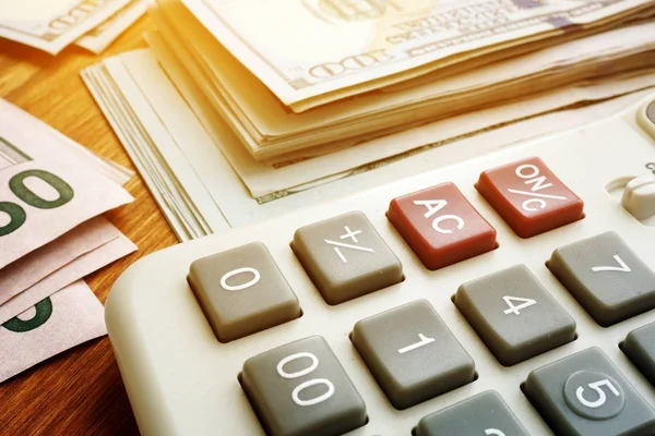 Stapel geld en Calculator. Budgettering en spaar concept. Dollar bankbiljetten op Bureau. — Stockfoto