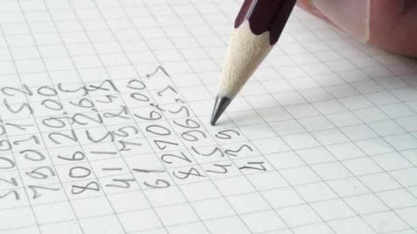 鉛筆はノートパッドに数字を書いています クローズアップ — ストック動画