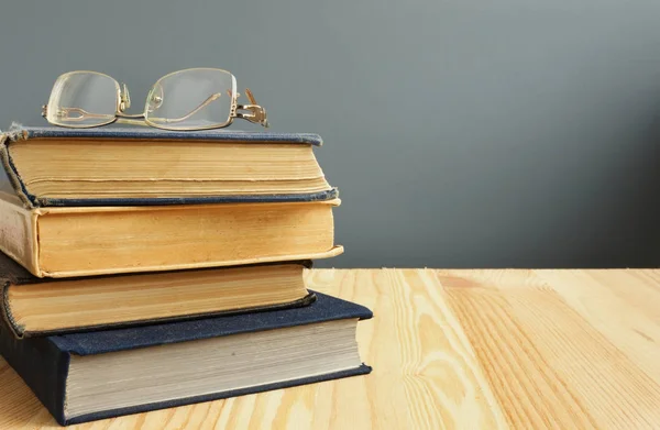 Retro boeken en oude brillen op houten tafel. — Stockfoto