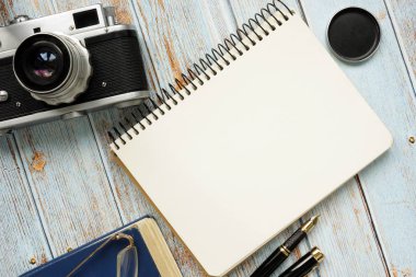 Not defteri ve retro fotoğraf makinesi boş sayfası. Masanın üst görünümü.
