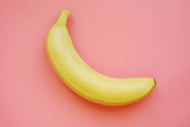 Pembe arka planda muz. Renkli meyve deseni.