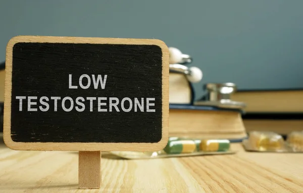 Firmare testosterone basso e libro su superficie di legno . — Foto Stock