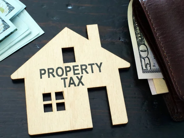 Belasting teken voor onroerende voorheffing op een huis model. — Stockfoto