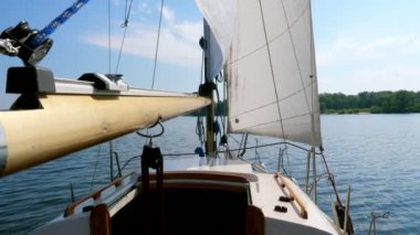 Nehir üzerinde beyaz yelkenli küçük yelkenli tekne.