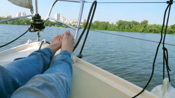 男は街に上がるヨットの船首の上に横たわっている 夏のレジャー — ストック動画