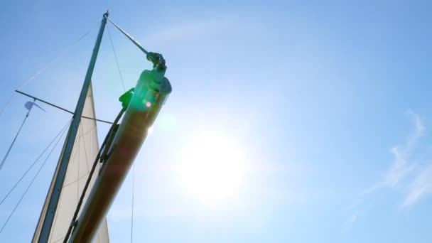 Voile blanche et mât au soleil et éblouissement en été .