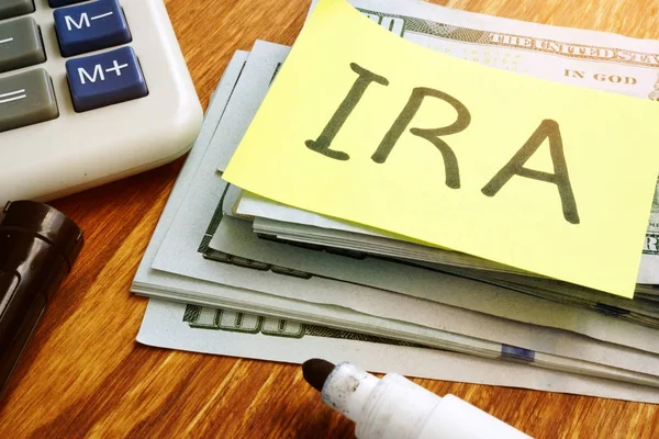 IRA individual retirement account. Stack of money and calculator.