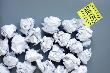 Motivasyon ve iş ilerleme sembolü olarak kağıt topları ve kelime başarı Lot.