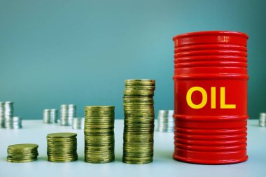 Petrol fiyatlarındaki artış kavramı. Madeni para ve varil yığını.