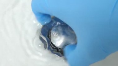 Tesisatçı lavaboyu banyodaki çamurdan temizliyor.