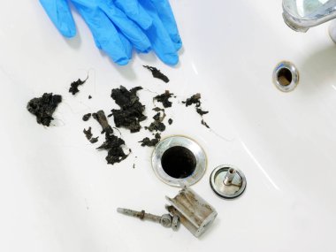 Clogged sink with mass of hair and grime in the bathroom. clipart