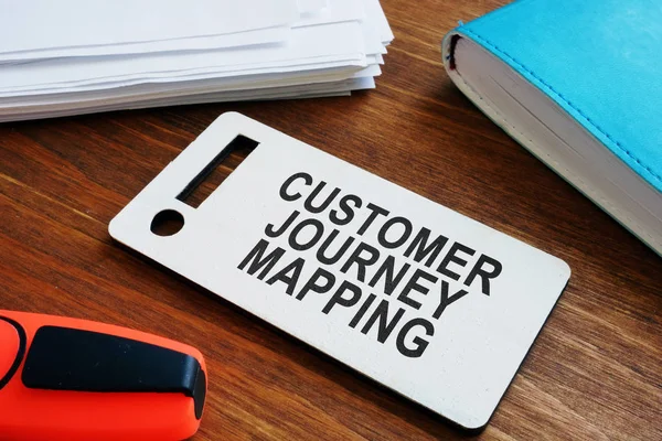 Plate with sign Customer journey mapping and papers with map.