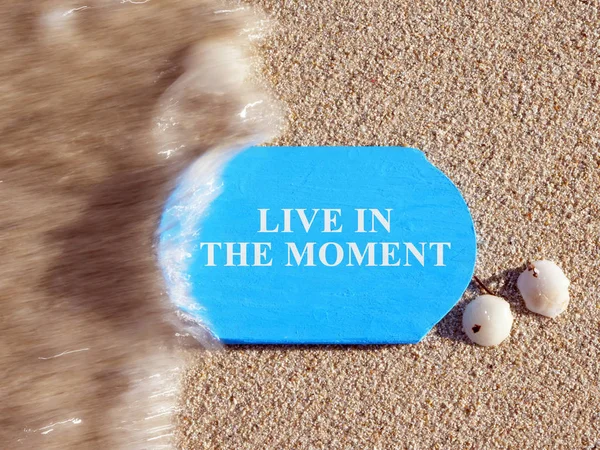 Live in the Moment sign on a blue plate.