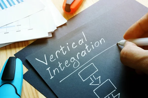 Man is writing about Vertical Integration. — Stock Photo, Image
