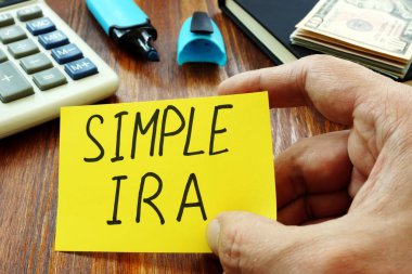 Simple IRA retirement plan in the hands of a man. clipart