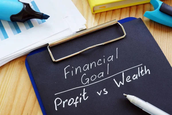 Finansiellt mål-vinst kontra rikedom fri form på skrivbordet. — Stockfoto