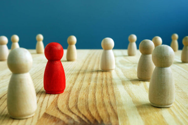 Социальная концепция включения. Красная статуэтка между деревянными фигурками
.