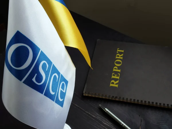 Drapeaux de l'OSCE et de l'Ukraine avec rapport sur le bureau . — Photo