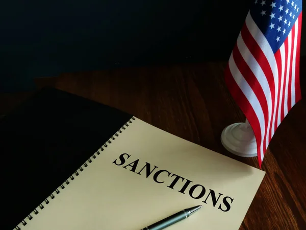 Sanciones estadounidenses y bandera de Estados Unidos sobre la mesa . —  Fotos de Stock