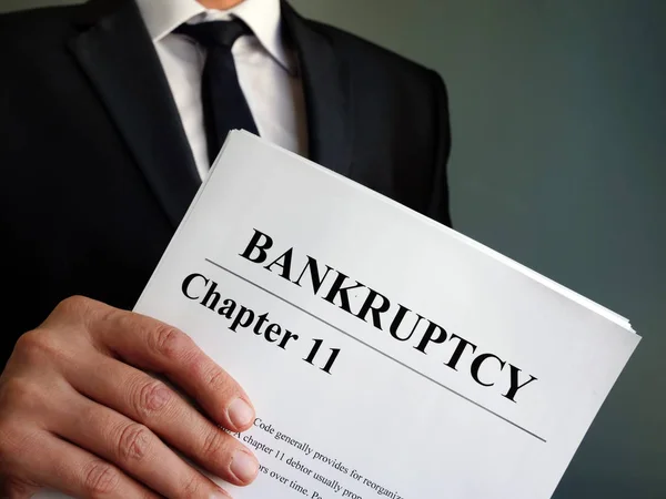 Man holds Bankruptcy Chapter 11 agreement documents. — Stock Photo, Image