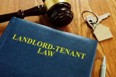 Landlord Tenant Law book and key from home. clipart