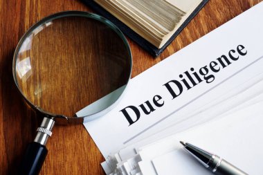 Diligence konsepti. Bir yığın belge ve büyüteç.