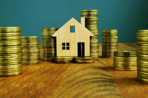 投资财产或抵押概念。 一排排的钱和木制的家. — 图库照片