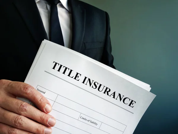 Title Insurance agreement in the hands of a businessman. — Stock Photo, Image