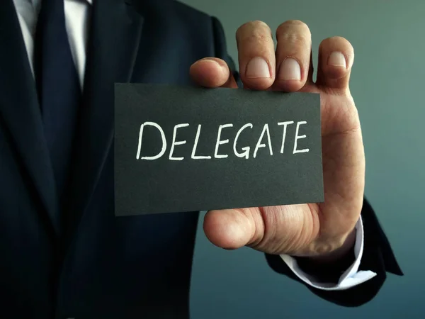 Delegiertenzeichen in den Händen eines Geschäftsmannes. Delegationskonzept. — Stockfoto