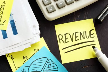 Revenue concept. Desk with stack of accounting documents.