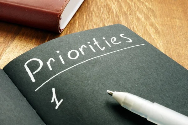Seznam priorit v černém notepadu. — Stock fotografie