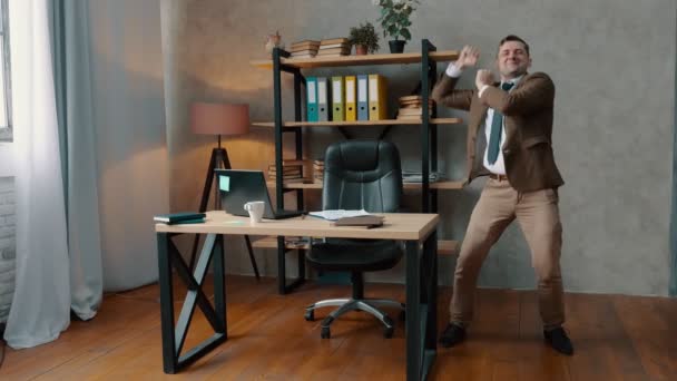 Un homme d'affaires joyeux en costume danse au bureau. Succès des entreprises . — Video