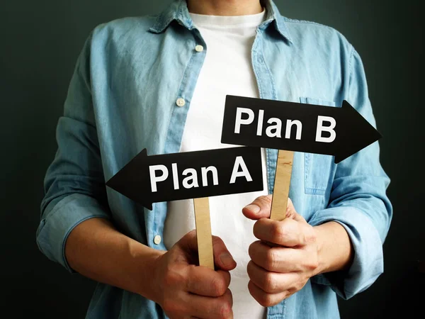 El hombre sostiene flechas plan A y plan B como símbolo de elección . — Foto de Stock