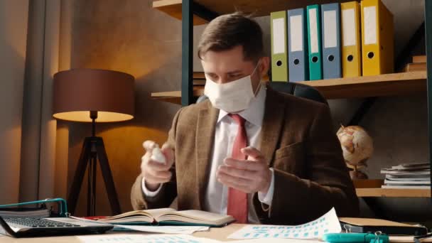 在大肠病毒流行期间工作。一个戴着医疗面罩的男人来到工作场所，用防腐剂消毒. — 图库视频影像