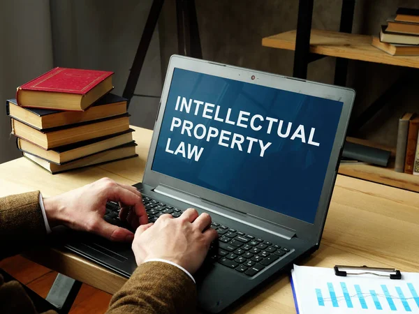 Právník čte o právu duševního vlastnictví na notebooku. — Stock fotografie