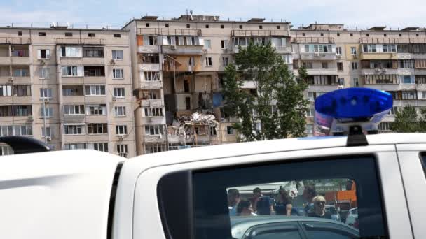 Kiev, Ucrania - 21 de junio de 2020 - Edificio residencial de varios pisos parcialmente destruido después de la explosión con el telón de fondo de un coche de policía . — Vídeos de Stock