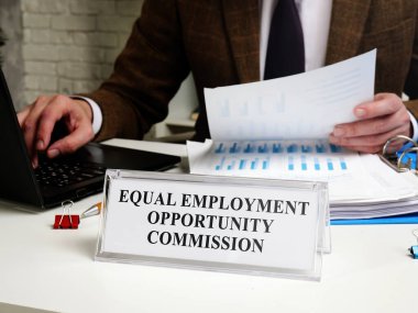 Tablet Eşit İstihdam Fırsatı Komisyonu EEOC ile masada çalışan bir erkek.