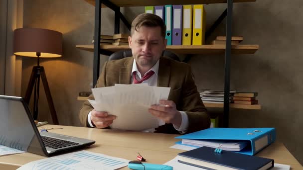 Un homme d'affaires énervé jette des papiers avec un rapport financier. Problèmes en affaires. — Video