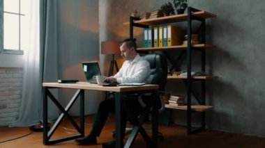 Ofisteki adam dizüstü bilgisayarda yazıyor..