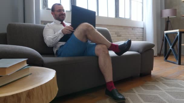 Op afstand werken. Een zakenman in shorts en een stropdas bespreekt in een videochat. — Stockvideo