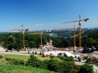 Yazın kentteki bir şantiyede inşaat vinçleri..