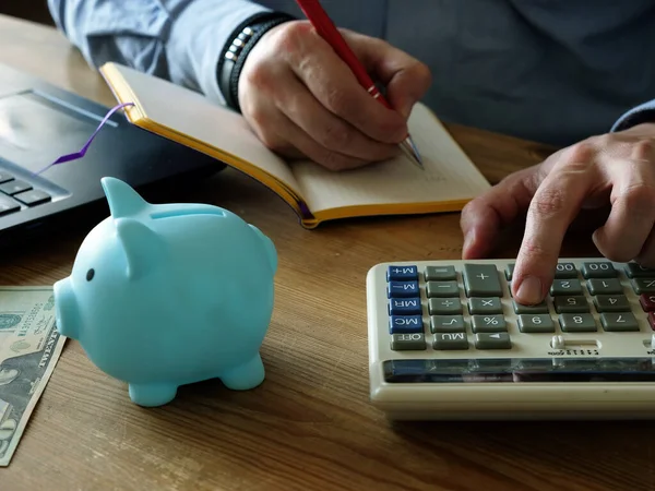 Finanzas locales. Un hombre calculando gastos mensuales y ahorros . —  Fotos de Stock