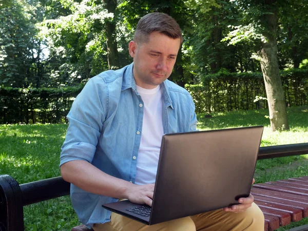 Concepto de comunicación. Chico joven en el parque charlando en Internet . — Foto de Stock