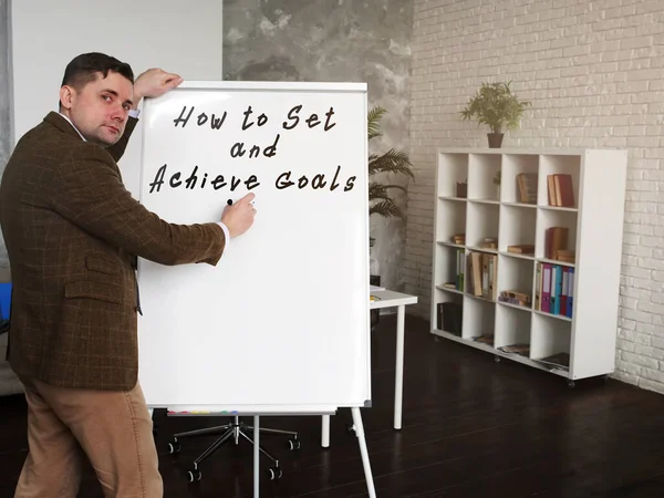 Mentor írja, hogyan kell célokat kitűzni és elérni. — Stock Fotó