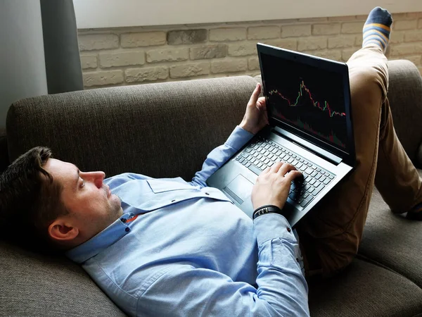 Un hombre en casa está analizando el comercio en un intercambio en línea . — Foto de Stock