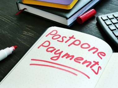 Ödemeleri ertele. Sayfa ve hesap makinesindeki kırmızı not. Erteleme veya hoşgörü kavramı.