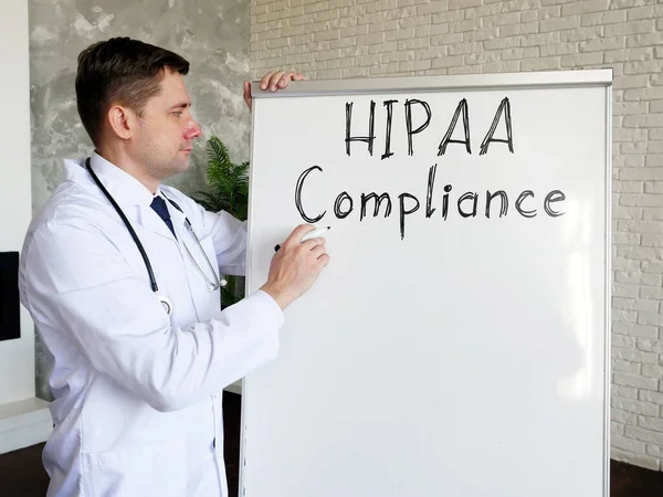 Доктор говорить про дотримання HIPAA і пише напис на дошці. — стокове фото