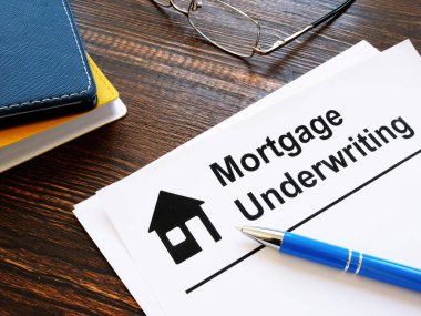 Information about mortgage underwriting and pen on the table. clipart